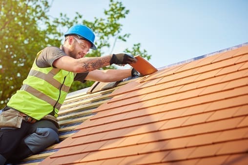 A roofer nails on the roof tiles in Owings Mills and Reisterstown, MD